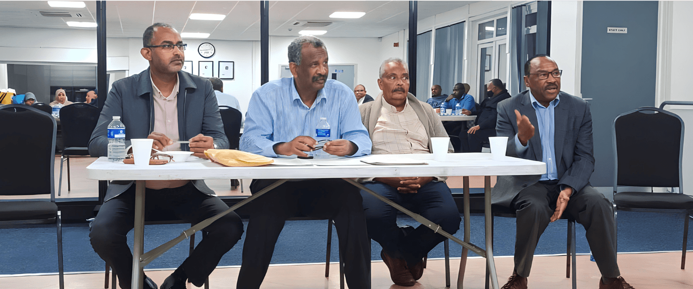 Men in discussion around a table at the centre