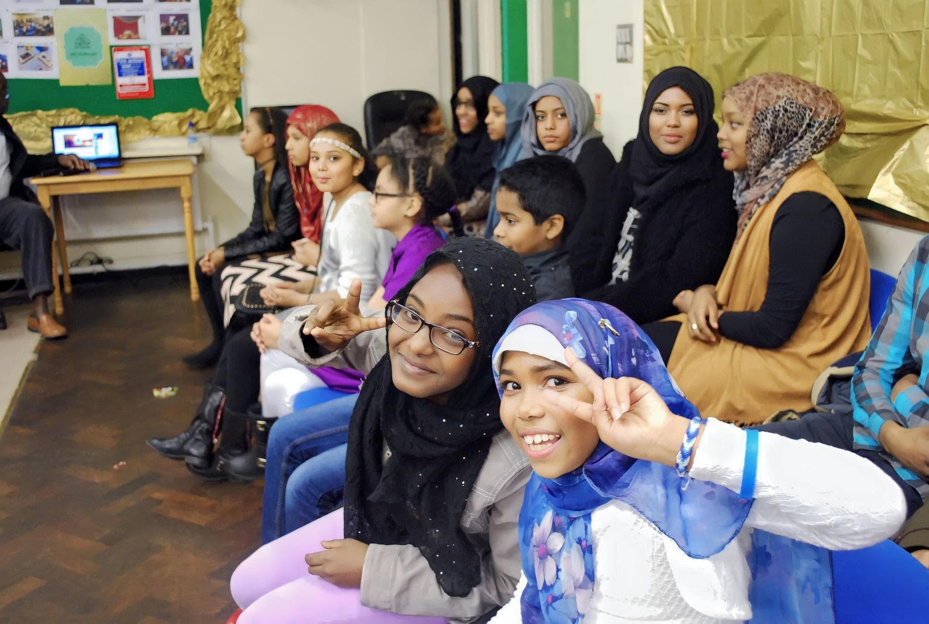 Children and adults seated together at a session in the centre