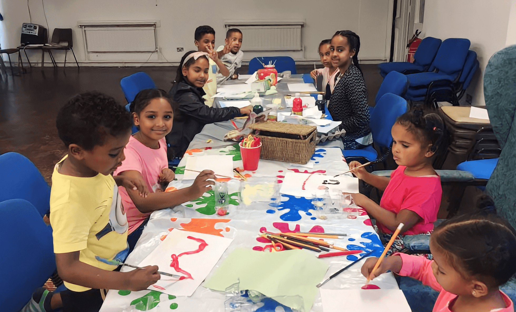 Children painting at a long table
