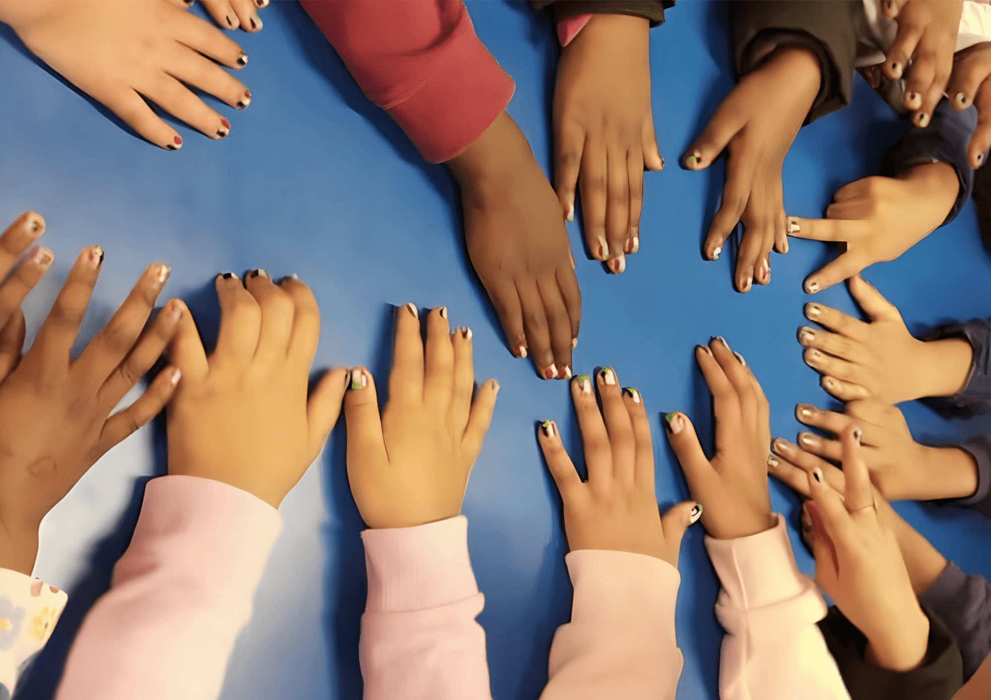Children from the centre placing their hands together around a table